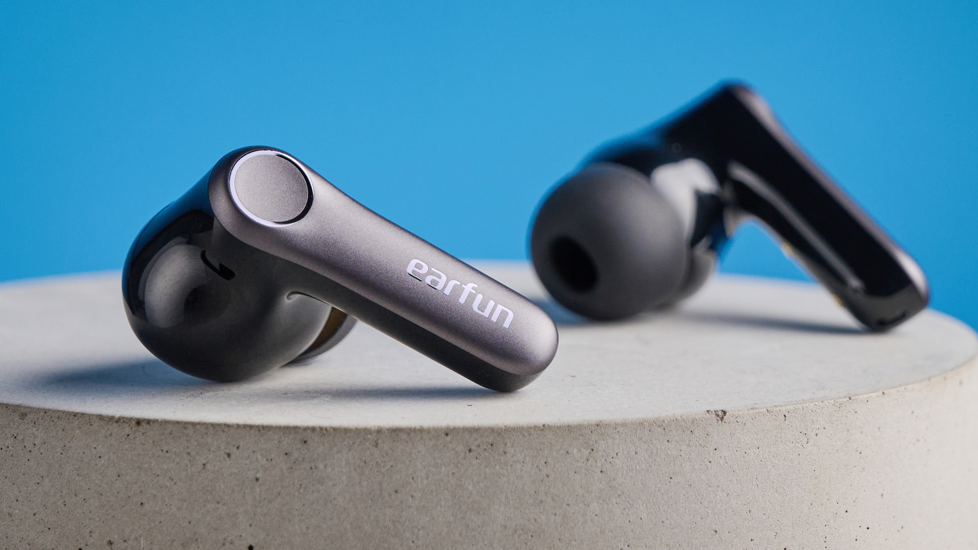 the earfun air pro 4+ earbuds in black showing the ear tips, charging case, and being worn