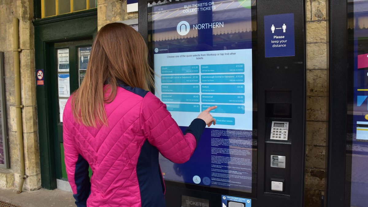 Woman purchasing ticket from Northern Railway&amp;#039;s self-service vending machine