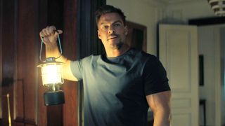 Reacher holding a lamp.