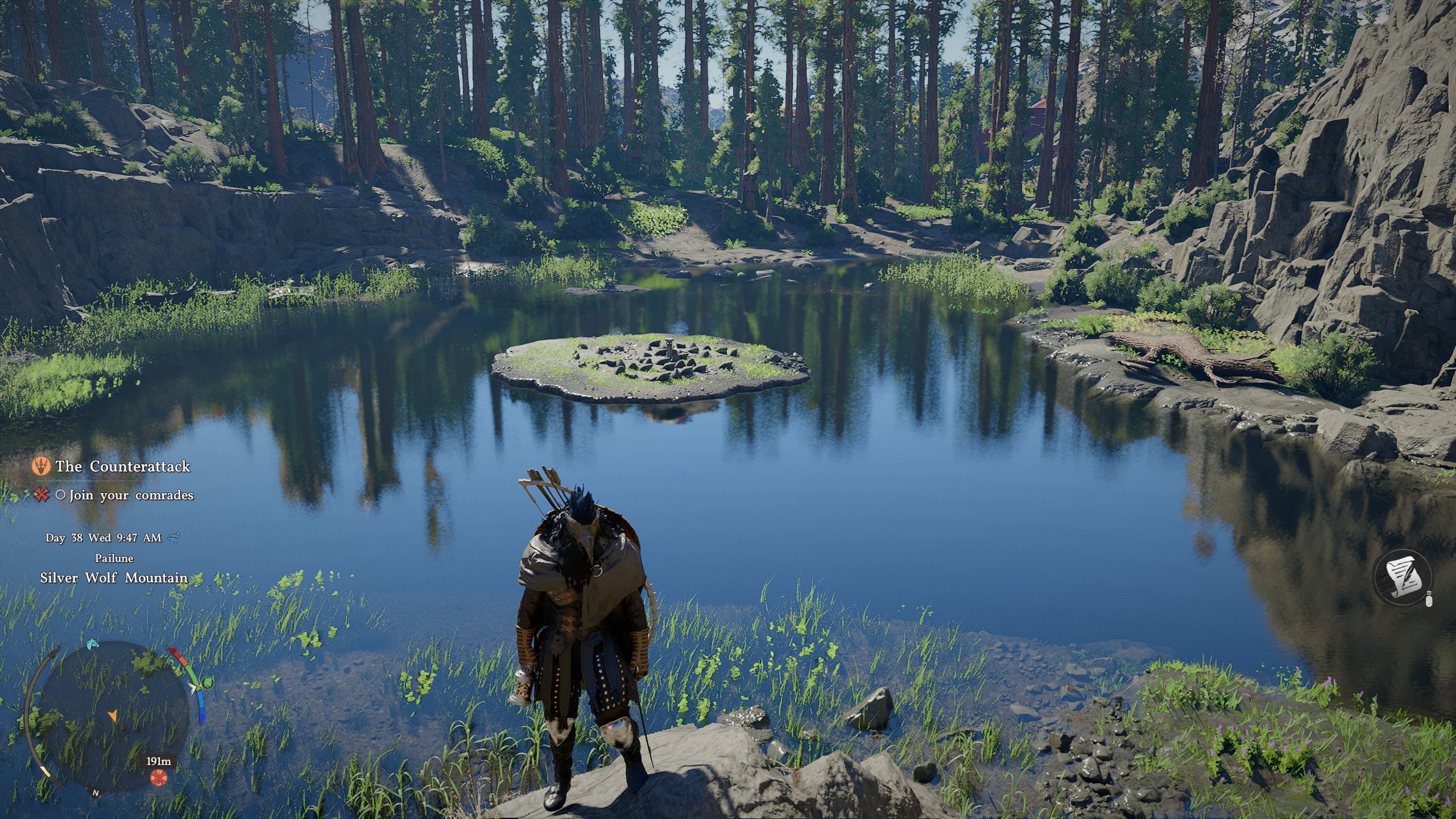 Kliff standing at the edge of a lake, looking away from the circle of land in the middle of it.