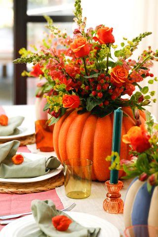 A pumpkin planter used as a centerpiece for a tablescape