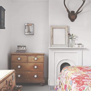chest of drawers with white handles in a bedroom