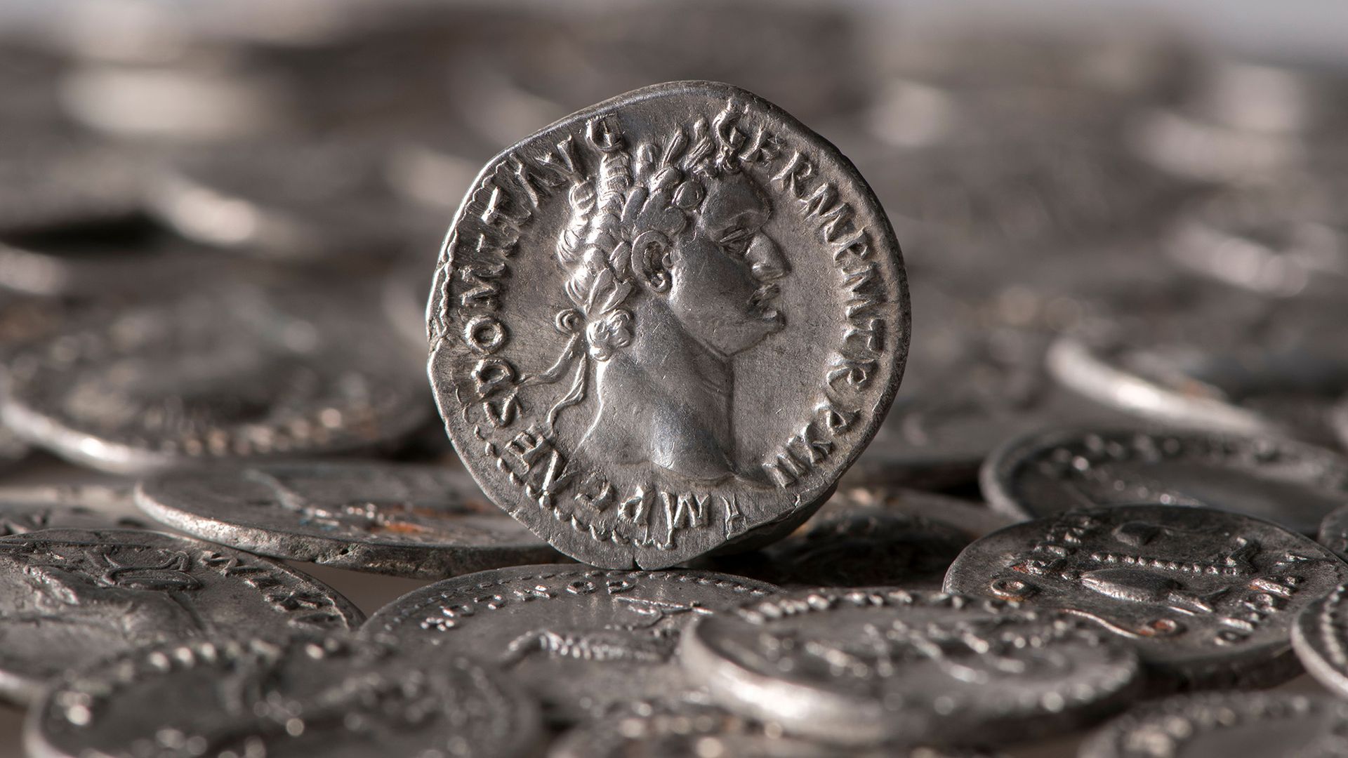 A close up of silver coins with various carvings in them.