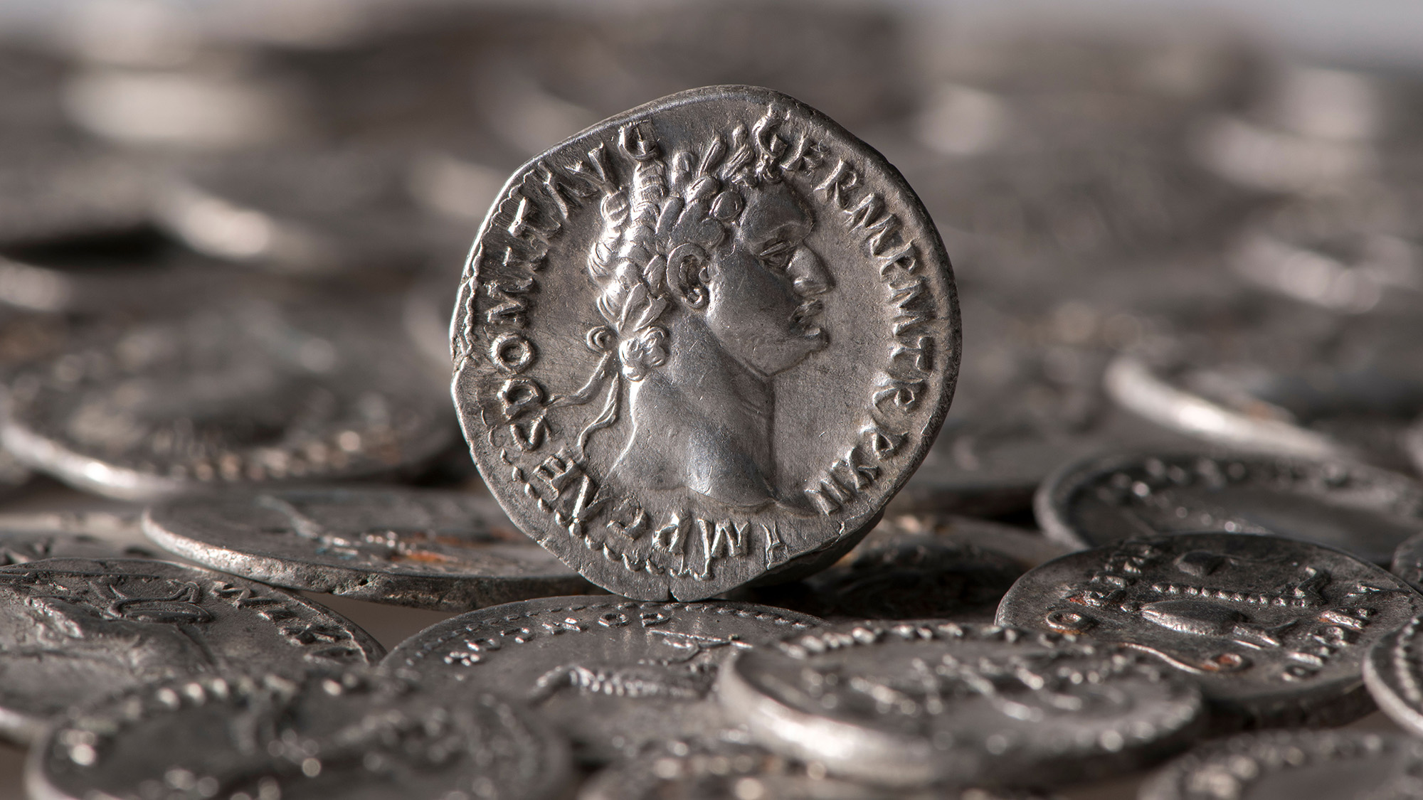A close up of silver coins with various carvings in them.