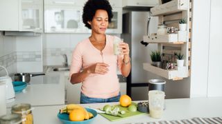 What to eat to build muscle after a workout: Image shows woman preparing a smoothie
