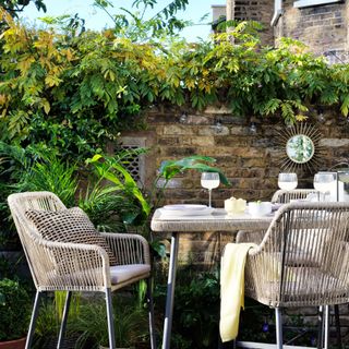 a patio garden with a tall rope-style dining table and chairs