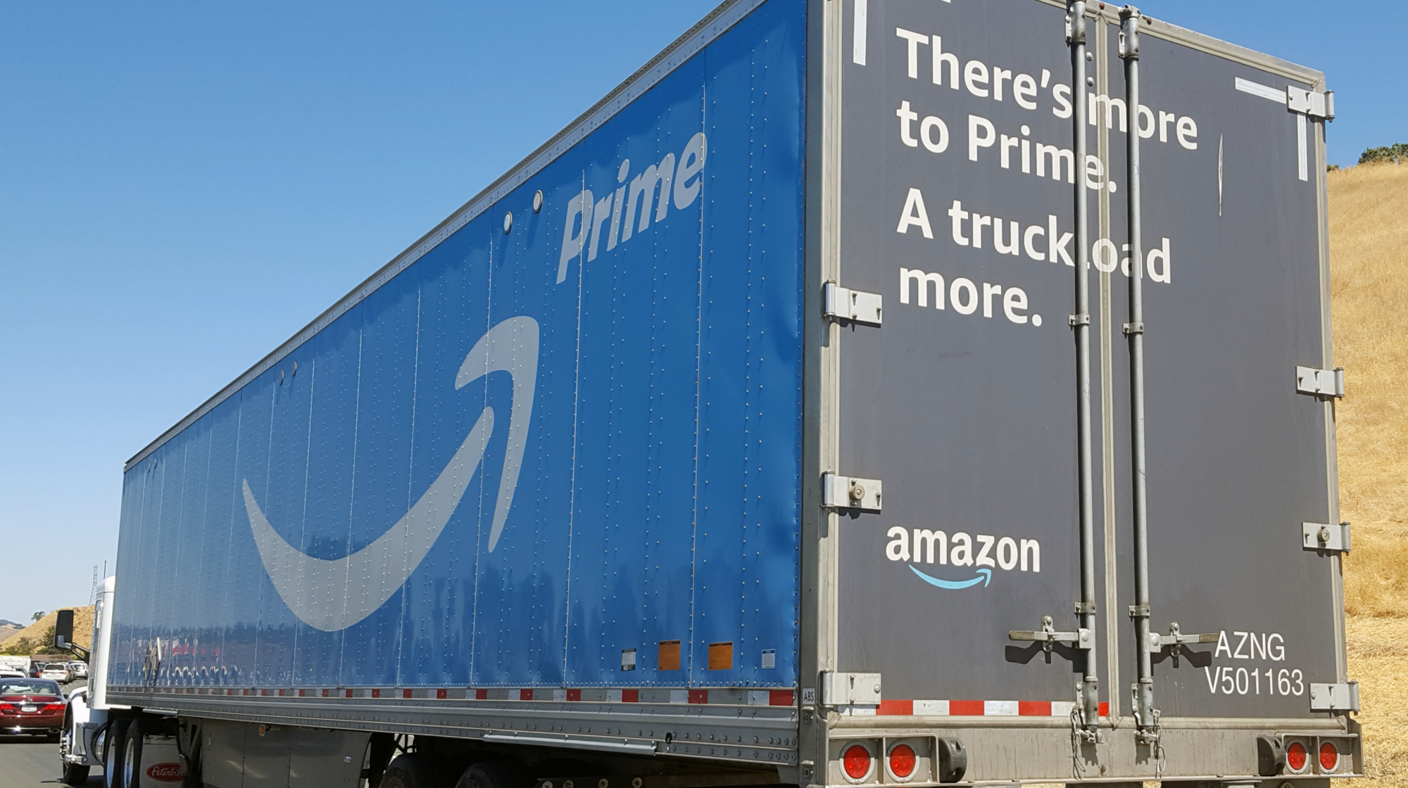 Tractor trailer semi truck with logos for Amazon Prime service and text reading "There's more to Prime, a truckload more" traveling on the 680 Freeway in Walnut Creek, California, July 31, 2017. Amazon is increasingly developing its own shipment and delivery infrastructure to avoid reliance on postal carriers. 