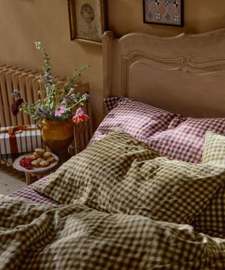 guest bedroom made up with gingham bedding in three colors with a side table with mince pies and a wrapped christmas gift