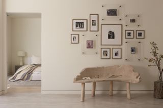 Neutral entryway with raw wood bench and gallery wall