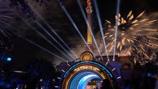 Photo of the nighttime celebration at Epic Universe with the Harry Potter Portal in the foreground and fireworks going off in the background.