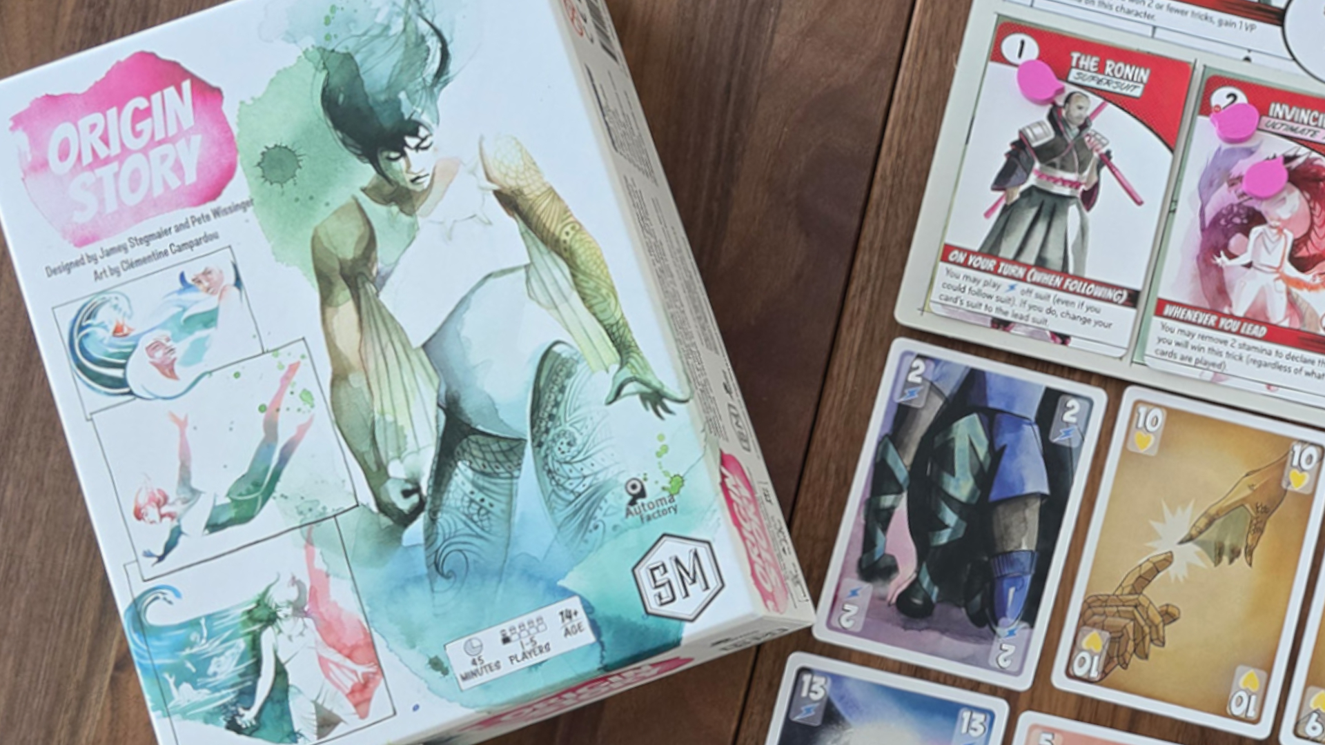 Origin Story box and cards laid out on a wooden surface