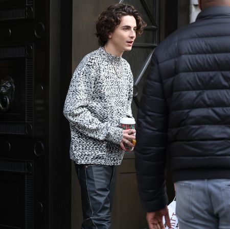 Timoth&eacute;e Chalamet in black leather pants and a gray sweater