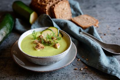 Bowl of cream of courgette soup with croutons and courgette slices