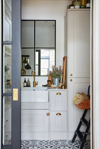 Grey Shaker-style utility room behind pocket door