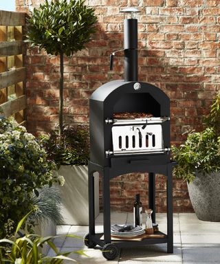 A charcoal pizza oven on a wheelie stand