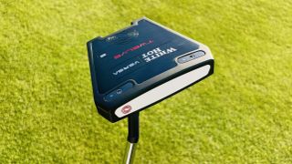 Odyssey White Hot Versa 12 Putter showing off its wide clubhead design on the golf course