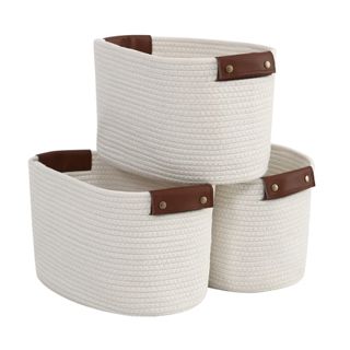 3 cream woven storage baskets with brown leather detail