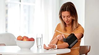 Woman using Garmin Index BPM blood pressure monitor
