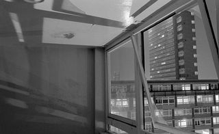 View out of an open window onto high-rise social housing