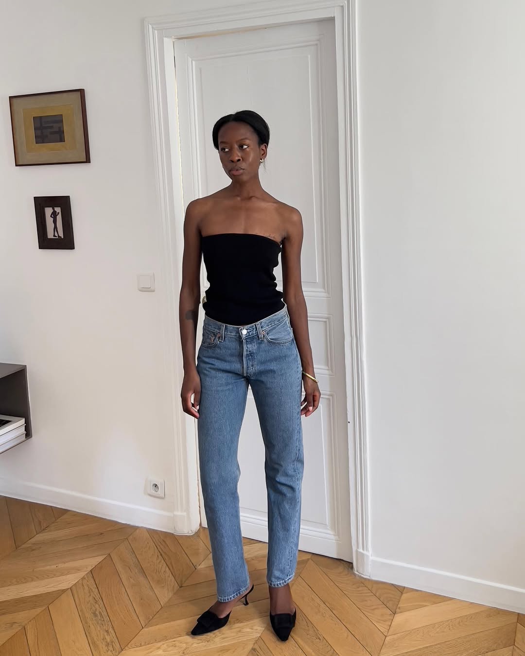 woman wearing strapless black top with slim jeans