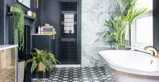 black bathroom with white marble shower enclosure, gold taps and multiple plants to show how to make a bathroom look expensive
