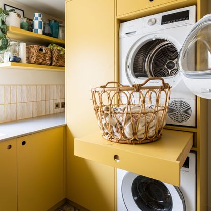 Utility room with yellow painted cabinets and a washer-dryer stacked on top of each other