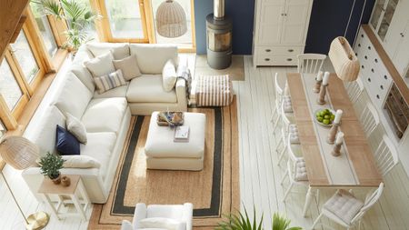 A light-colored living room with L-shaped sofa with dining table