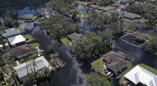 In this aerial view, a neighborhood flooded by the rising Myakka River is shown in the wake of Hurricane Ian on October 01, 2022 in North Port, Florida.