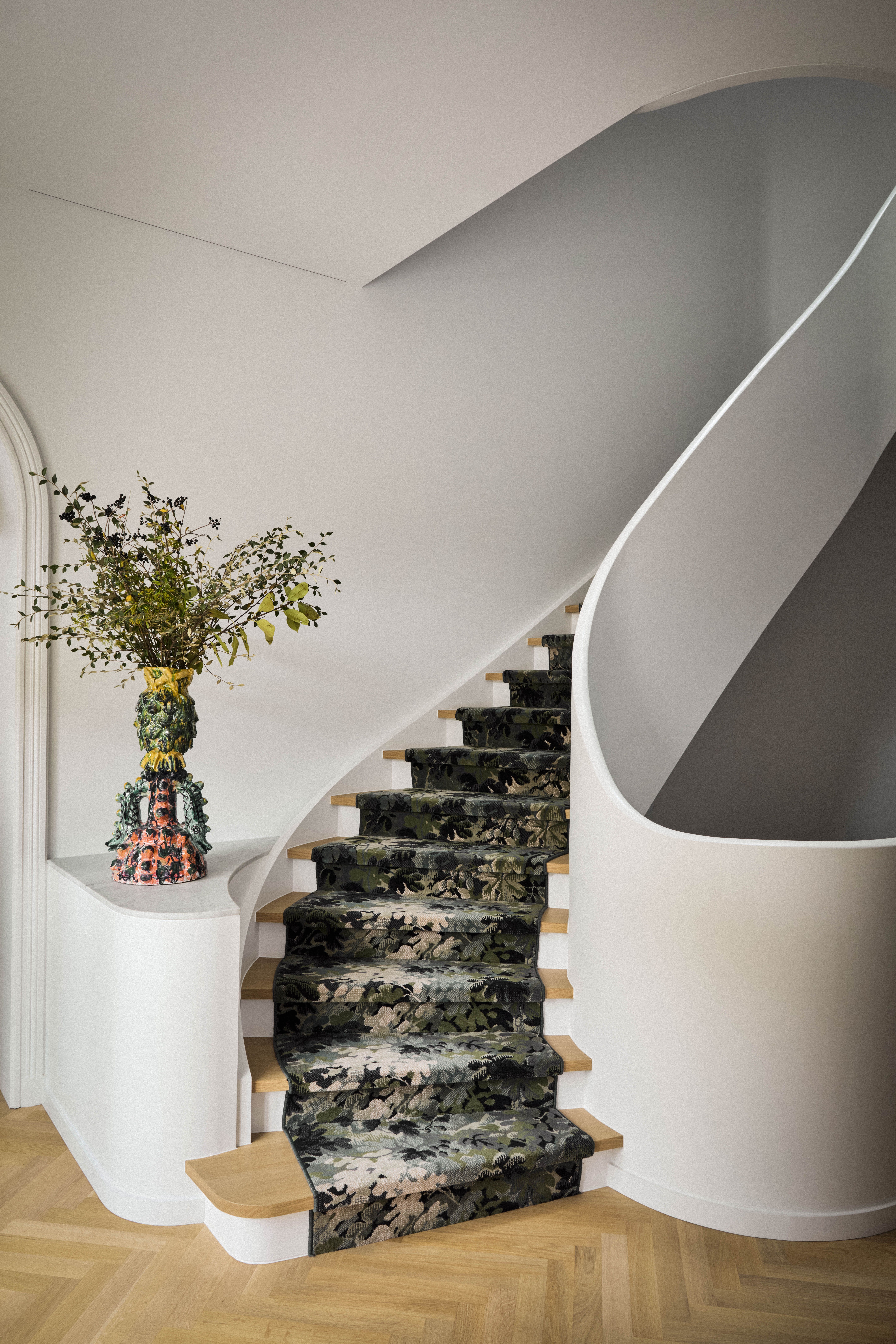 This winding staircase has a sculptural quality, with a printed runner 