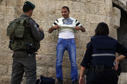 Israeli police check a Palestinian man amid a rash of stabbings