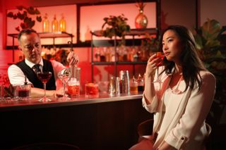 Canon EOS R5 Mark II sample image: a woman sat at a bar, holding a drink, while the bartender mixes a cocktail