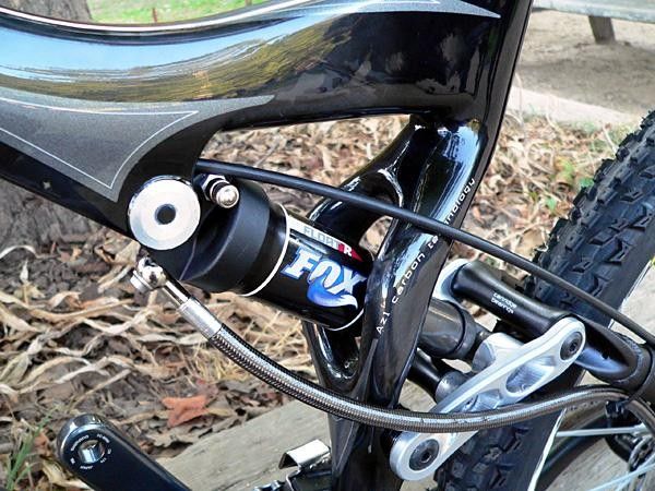 The Stumpjumper linkage is forged from magnesium as opposed to the carbon unit on the Epic. Dramatically swoopy carbon fiber design work is evident just about everywhere. Hydraulic hose running from the main shock routes oil out back to the remote Brain unit.