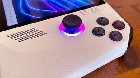 Close up of Asus ROG Ally buttons and thumbstick sitting on woodgrain table.