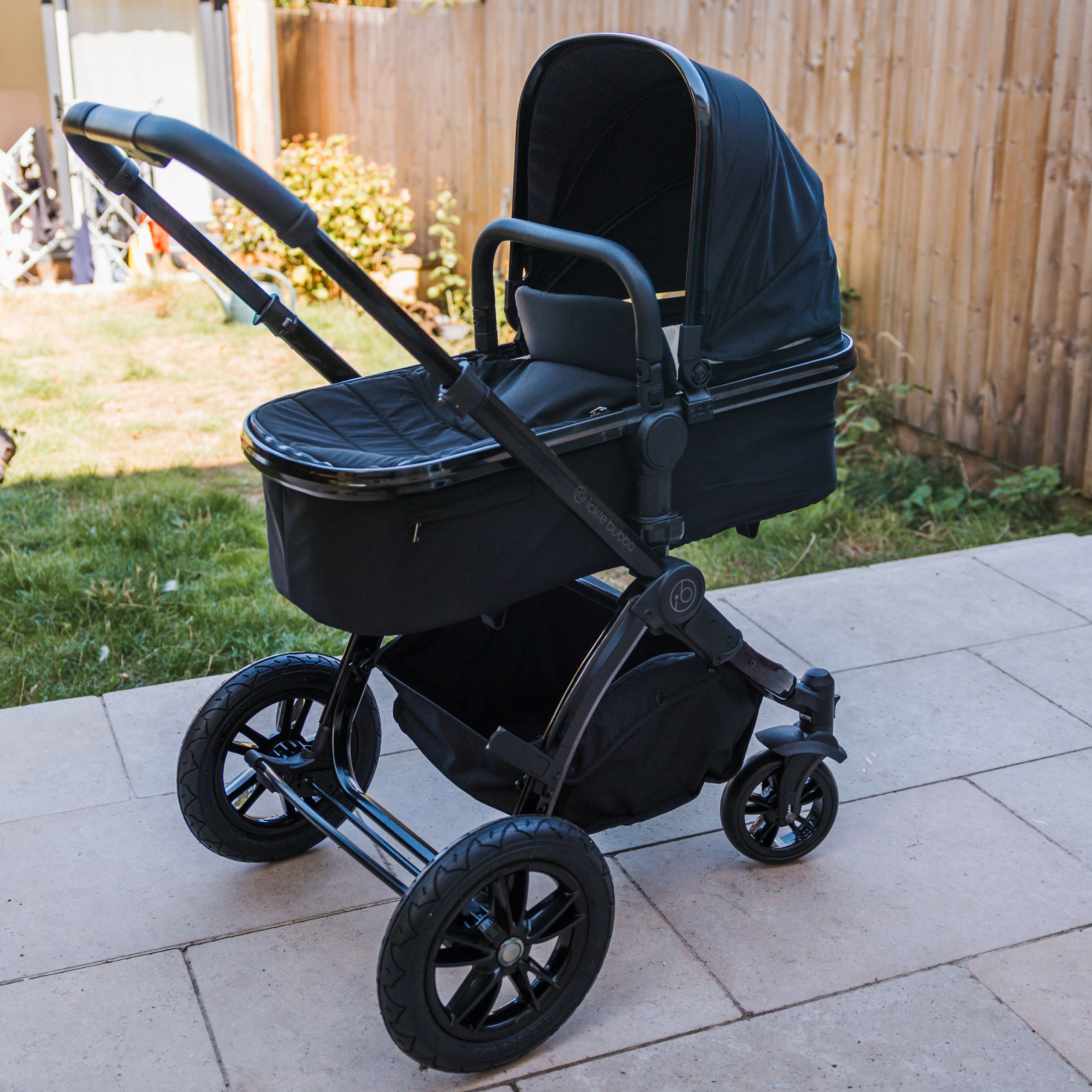 The Ickle Bubba Stomp Luxe Elements pram in a garden