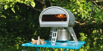 outdoor kitchen with pizza oven and pots of herbs and flowers