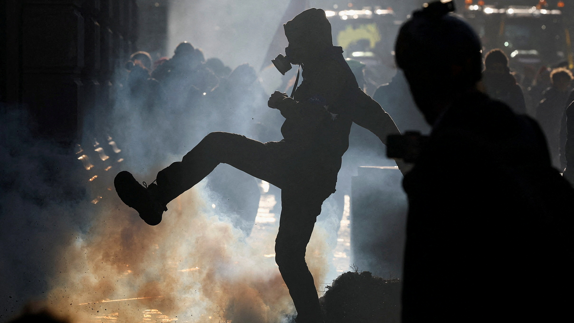 A protester kicks a tear gas canister during a farmers' demonstration against the EU-Mercosur free trade deal in Brussels, Belgium
