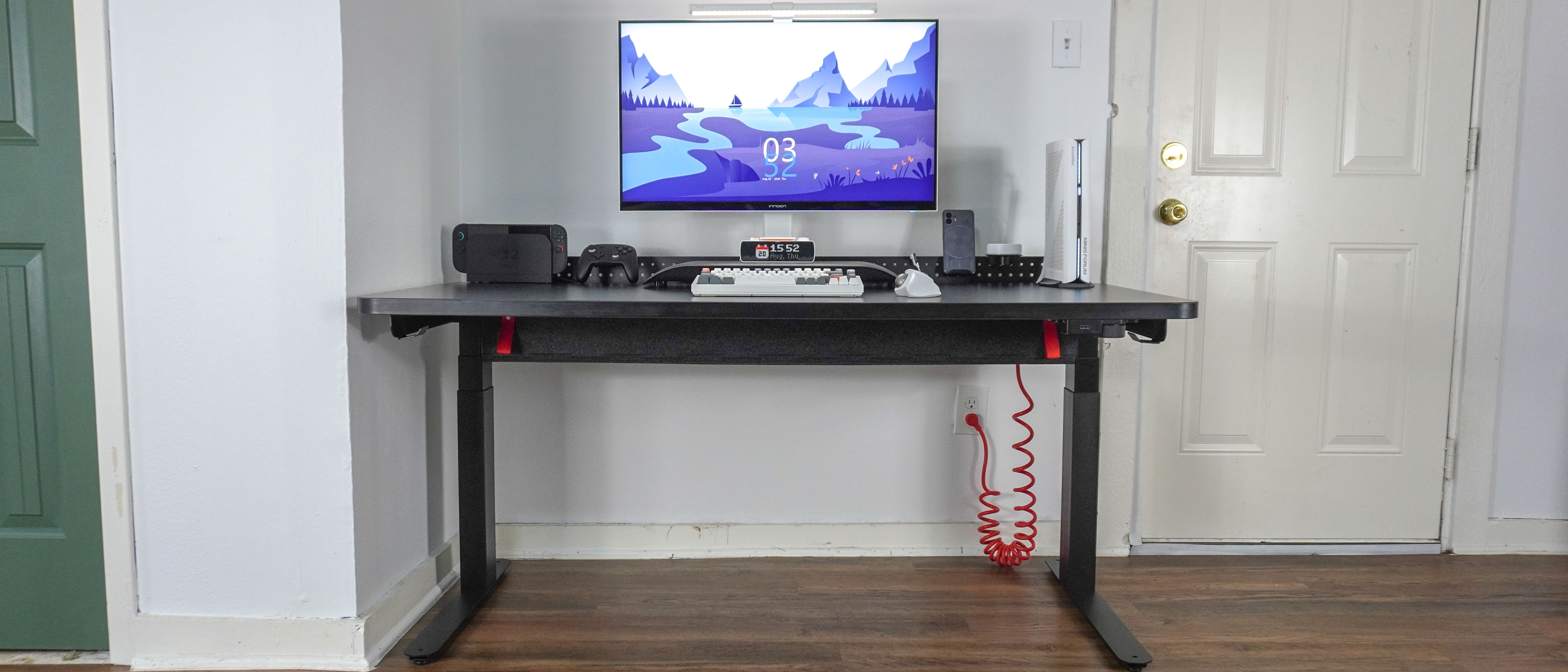 The Herman Miller Coyl Gaming Desk set up in a corner with a PC, monitor and other accessories on top