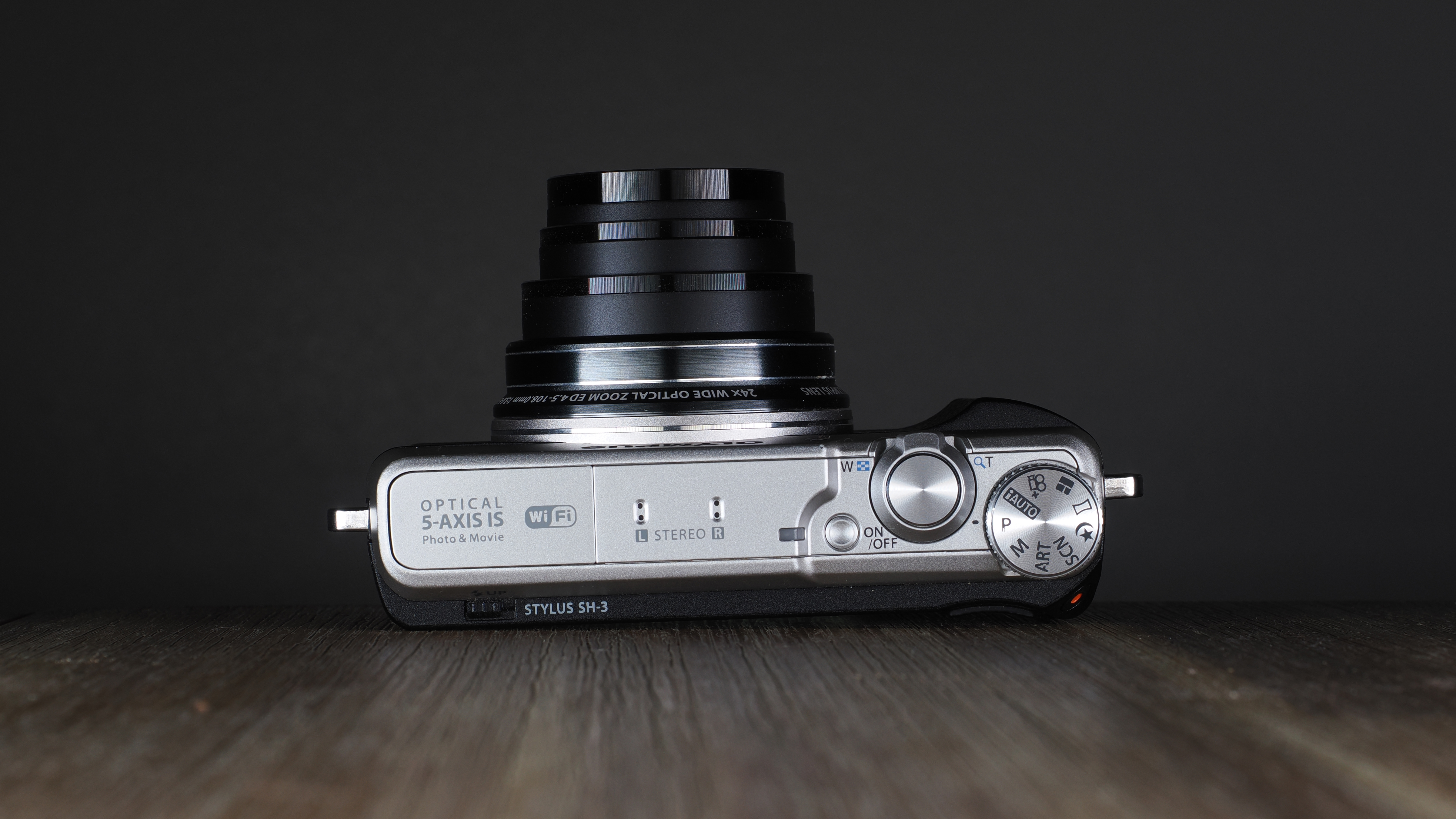 Olympus Stylus SH-3 on a wooden surface