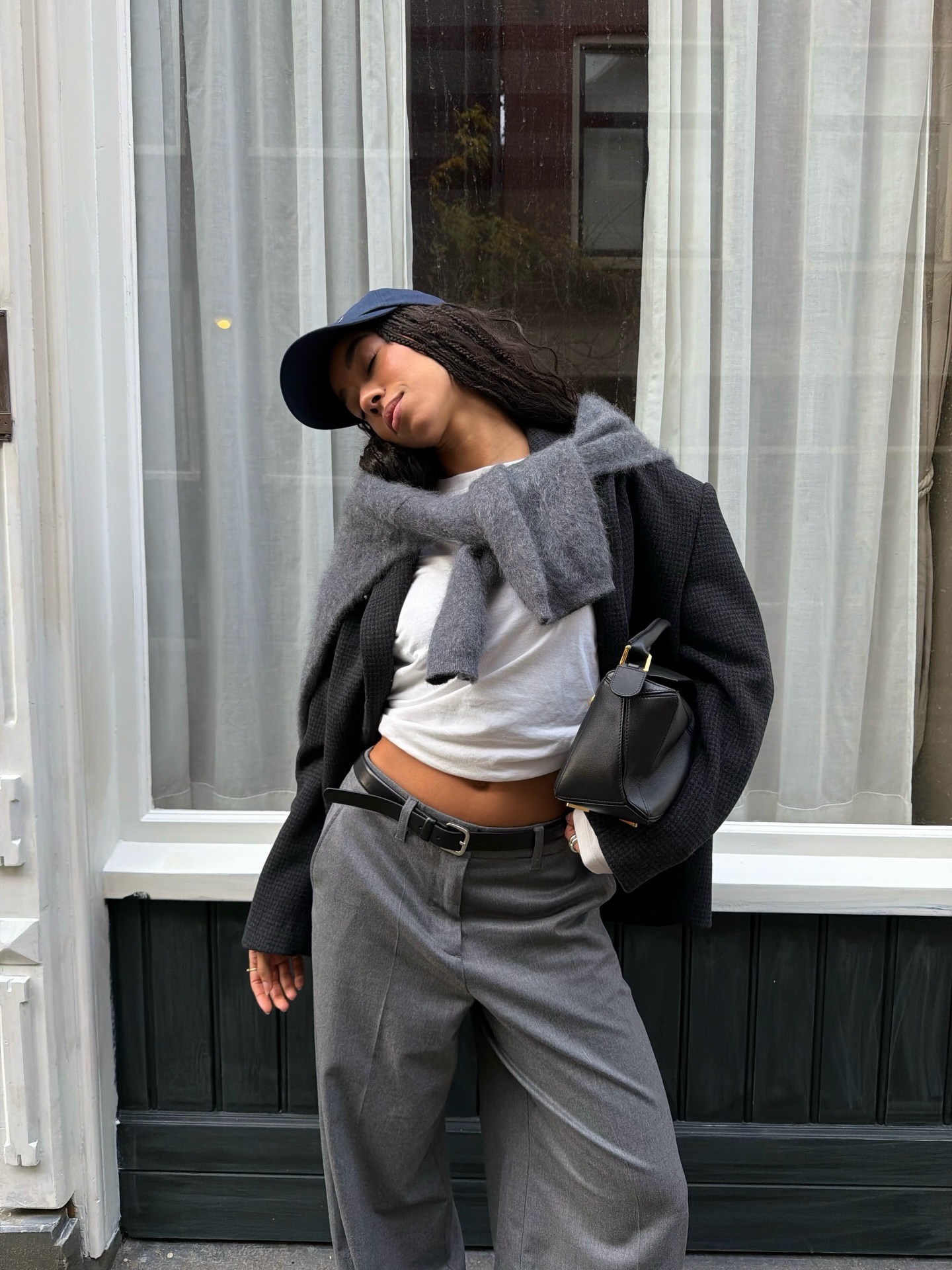 A woman in a grey blazer wearing a navy cap with her hair down