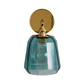 A blue glass wall sconce with a brass base