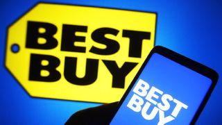 Man holiding phone with best Buy logo with blue background against anohter Best Buy logo