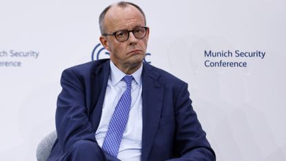 German Chancellor, Friedrich Merz, in front of a backdrop that says munich security conference