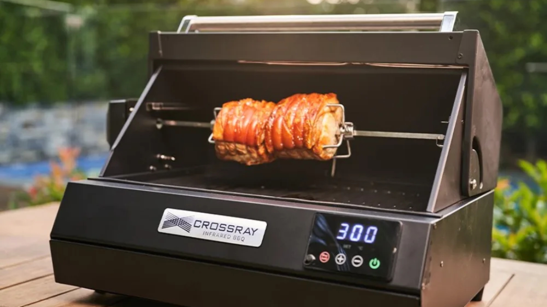 Dimplex Crossray eXtreme Portable Electric BBQ on a table with meat cooking on it
