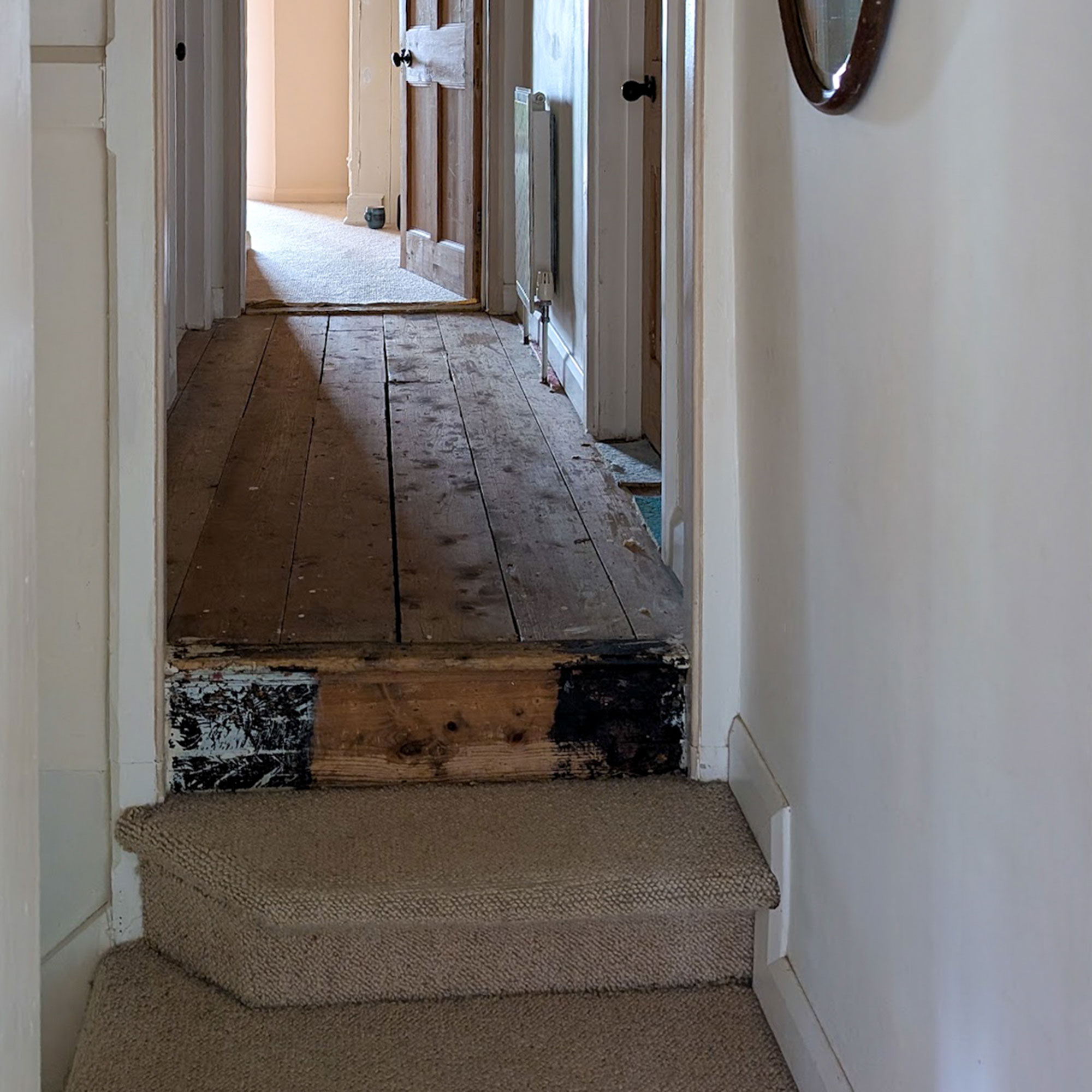 Hallways with bare floorboards after carpet has been removed
