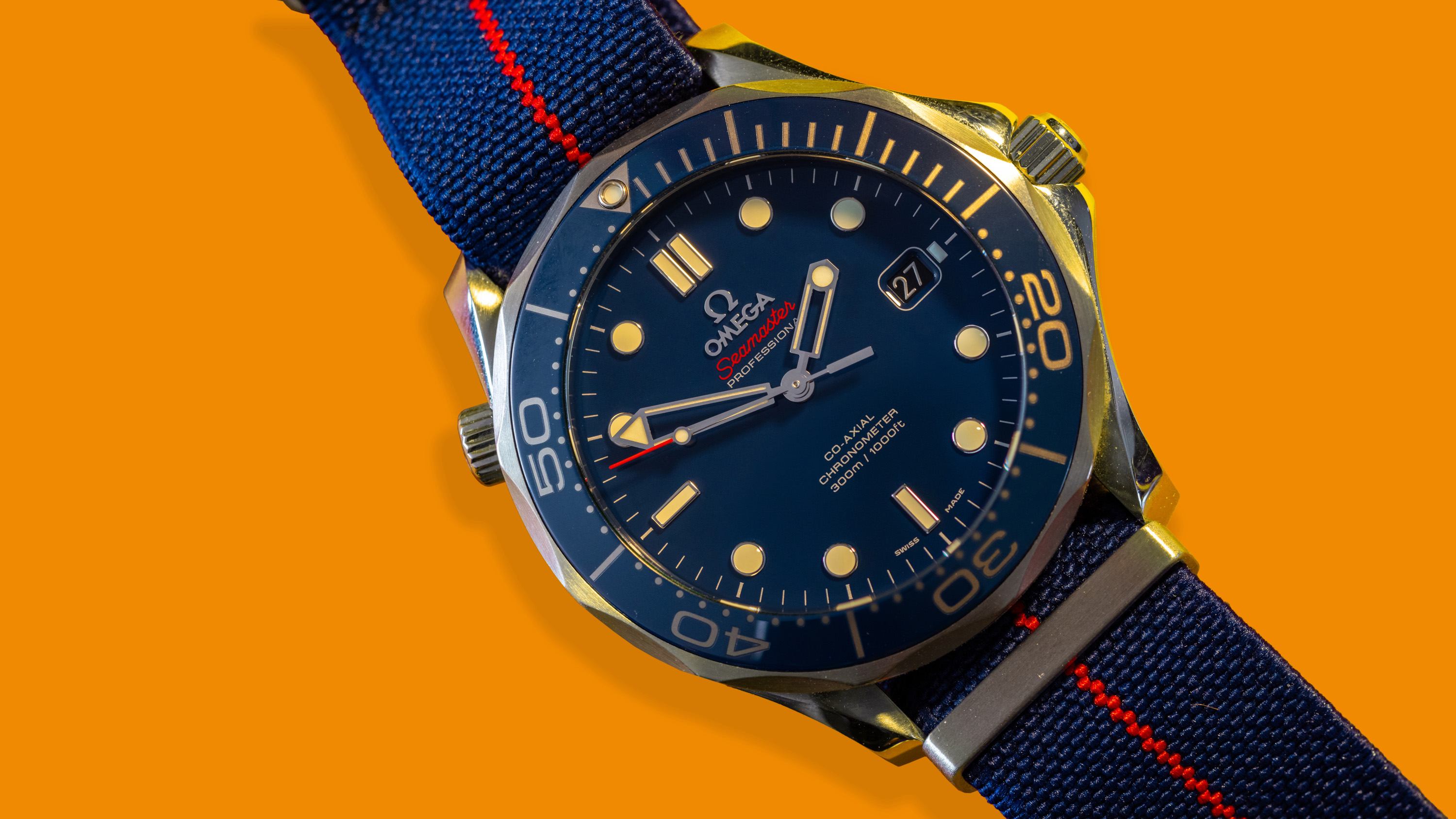 A blue Omega Speedmaster on a orange background