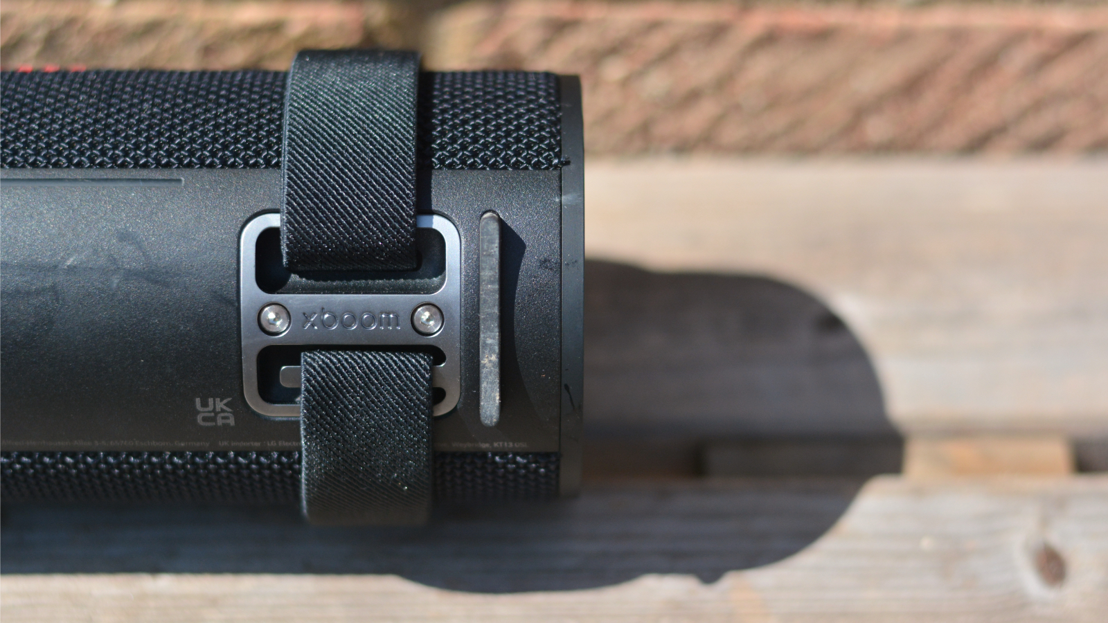 LG xboom Grab Bluetooth speaker in an outdoor setting