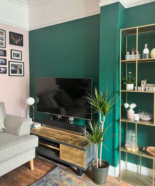 Gold leaf finished TV stand in teal green living room space