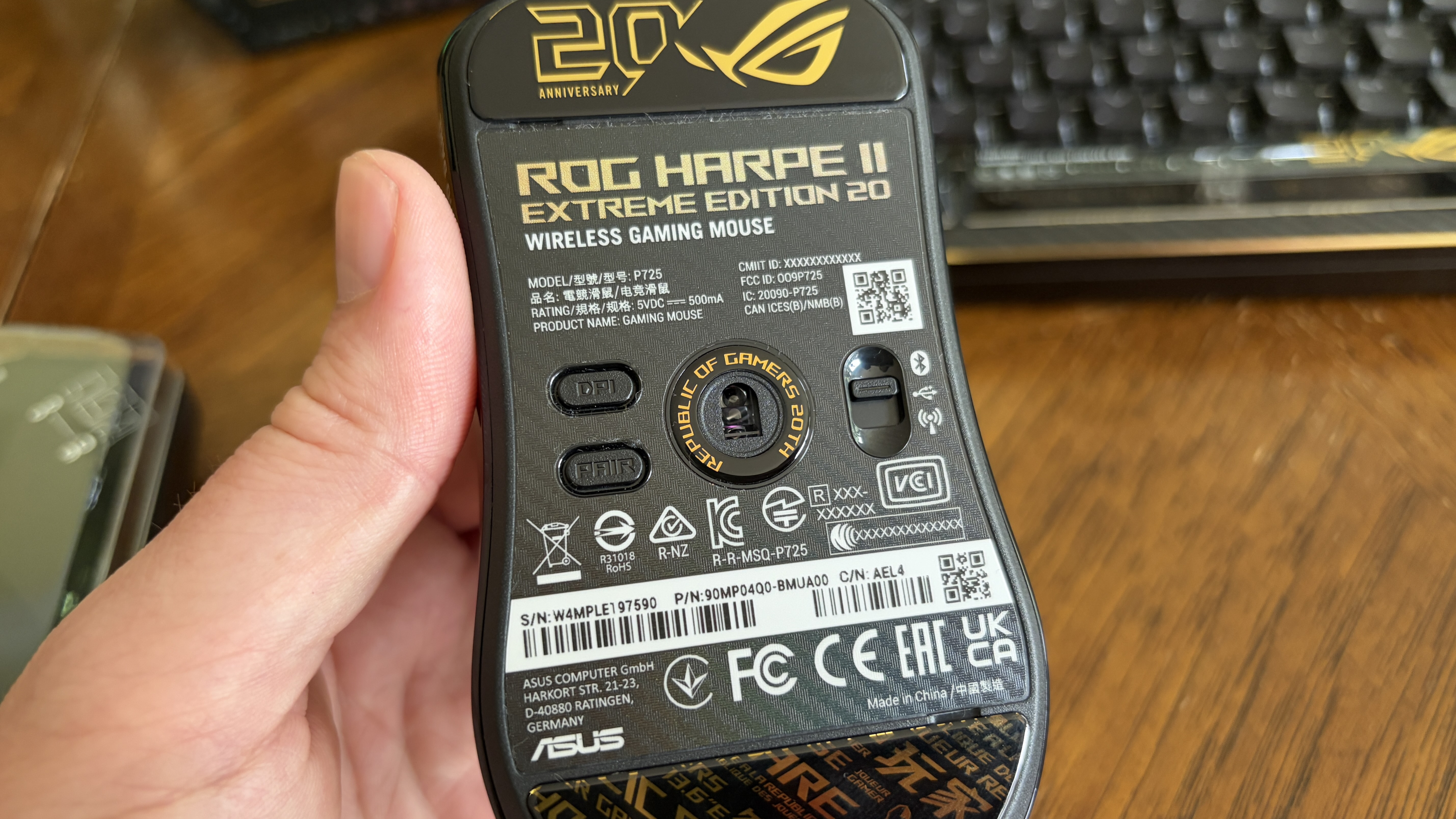 Bottom of a black and gold "ROG Harpe II Extreme Edition 20" wireless gaming mouse with branding and technical details.