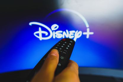 شعار Disney Plus مع جهاز التحكم عن بُعد