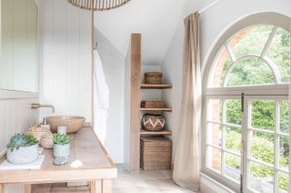 bathroom with arched window and neutral colors